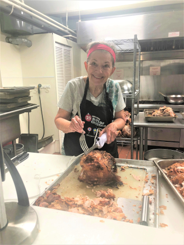 Photo of a woman carving turkey breasts in a kitchen