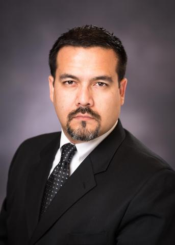 Edgar Samayoa, a male-presenting individual with brown hair and a goatee, looks directly at the camera