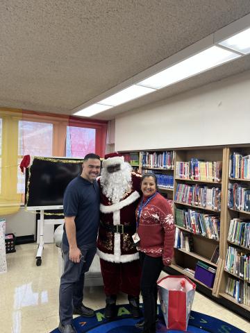 Santa, also known as CTPF Executive Director Carlton W. Lenoir, Sr., shared some holiday cheer at Yates Elementary School, pictured here with Principal Israel Perez and Assistant Principal Concepcion Calderon. 