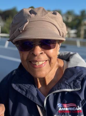 Photo of Retiree Edwina R. Justice. She is outside wearing a thick jacket, a hat, and sunglasses.